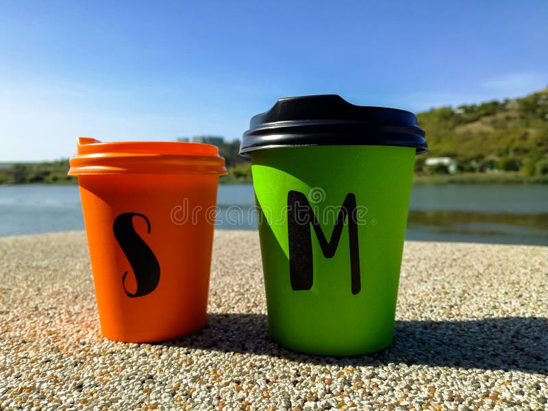 Two Multicolored Disposable Portable Paper Coffee Cups of Different