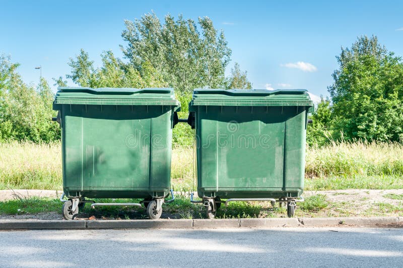 Two new green garbage dumpster cans on the street stock photo Two new green garbage dumpster cans on the street stock photo