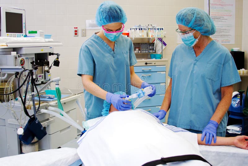 Two Nurses With Patient In Operating Room Stock Photo - Image of