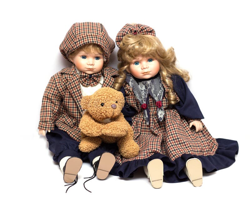 Two old, ceramic dolls and a teddy bear. Old porcelain doll on White Background stock image Two old, ceramic dolls and a teddy bear. Old porcelain doll on White Background stock image