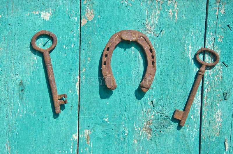 Two old rusty historical key and luck symbol horseshoe on wall