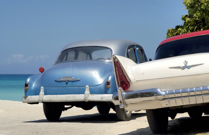Two old vintage cars at beach in Cuba stock photography