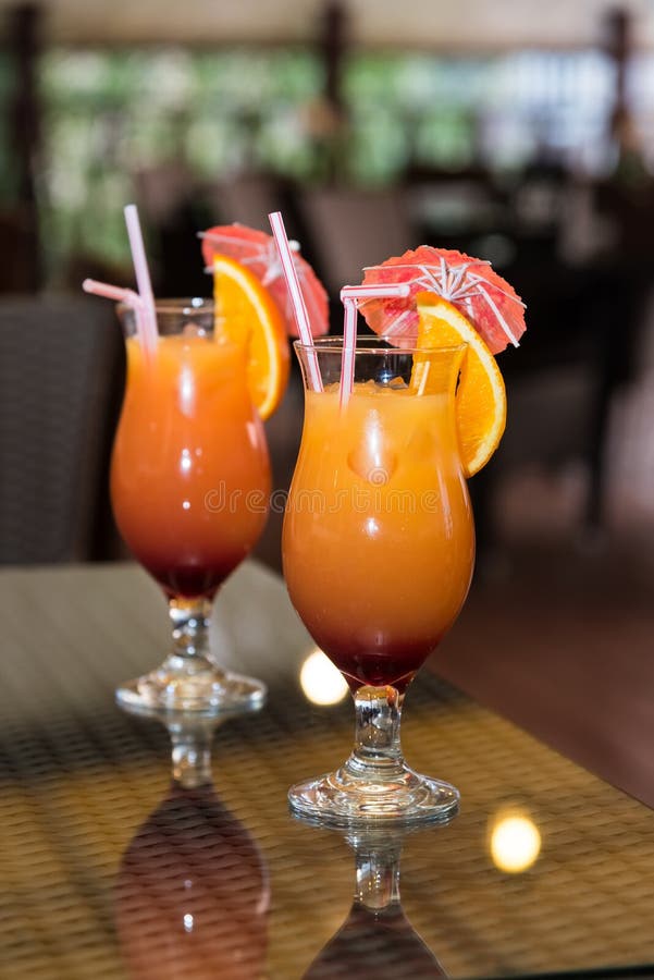 Two Orange Cocktails Decorated With A Slice Of Orange, Olive And Mint ...