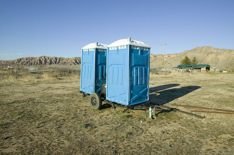 Two out houses, mobile blue bathrooms, sit on trailer in the middle of a field in Ventura County, California off of highway 33. Near Cuyama stock photo Two out houses, mobile blue bathrooms, sit on trailer in the middle of a field in Ventura County, California off of highway 33. Near Cuyama stock photo