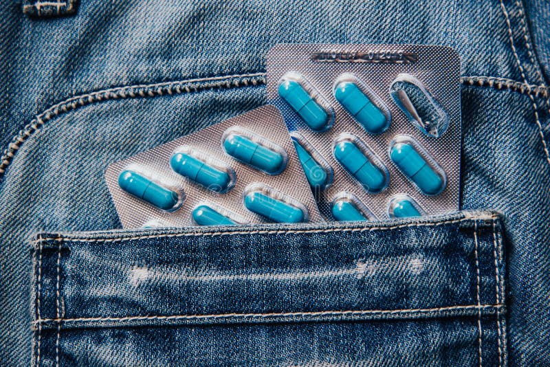 Two packages of blue capsules in the pocket of his pants.Pills for men`s health and sexual energy in jeans. Concept of erection, potency. Treatment of male infertility, impotence and prostatitis