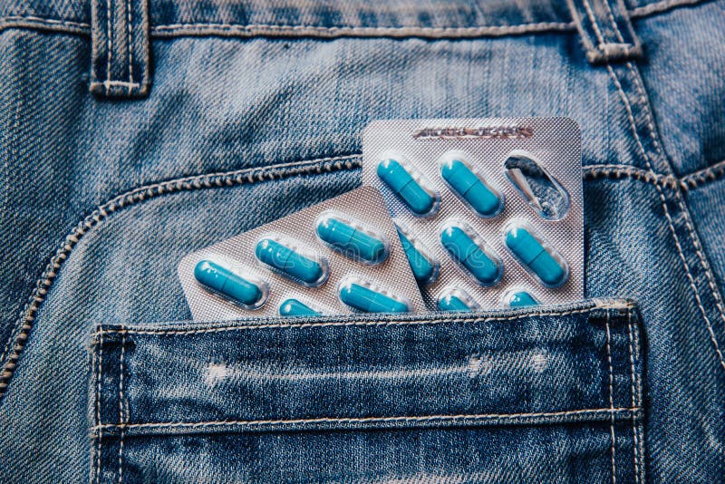 Two packages of blue capsules in the pocket of his pants.Pills for men`s health and sexual energy in jeans. Concept of erection, potency. Treatment of male infertility, impotence and prostatitis