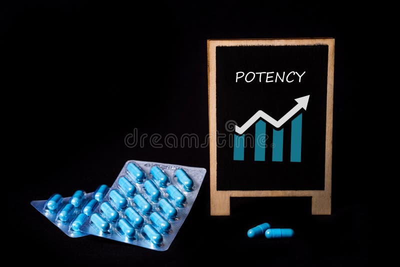 Two packs of blue capsules and the word potency on a chalkboard. Pills for men`s health and sexual energy. Concept of erection, potency. Treatment of male infertility and impotence and prostatitis