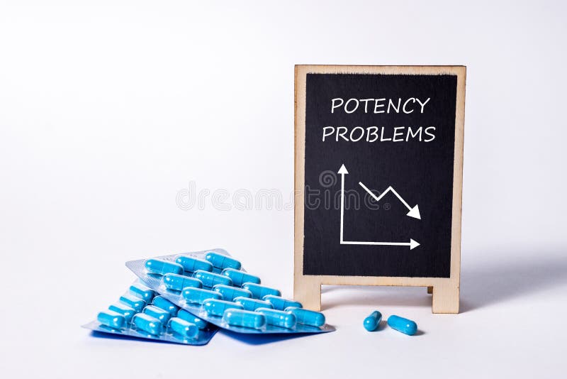 Two packs of blue capsules and the word Potency problems on a chalkboard. Pills for men`s health and sexual energy. Concept of a bad erection. Treatment of male infertility and impotence. Copy space