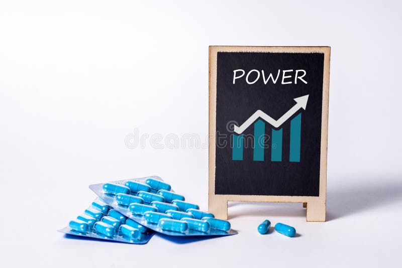 Two packs of blue capsules and the word power on a chalkboard. Pills for men`s health and sexual energy. Concept of erection, potency. Treatment of male infertility and impotence