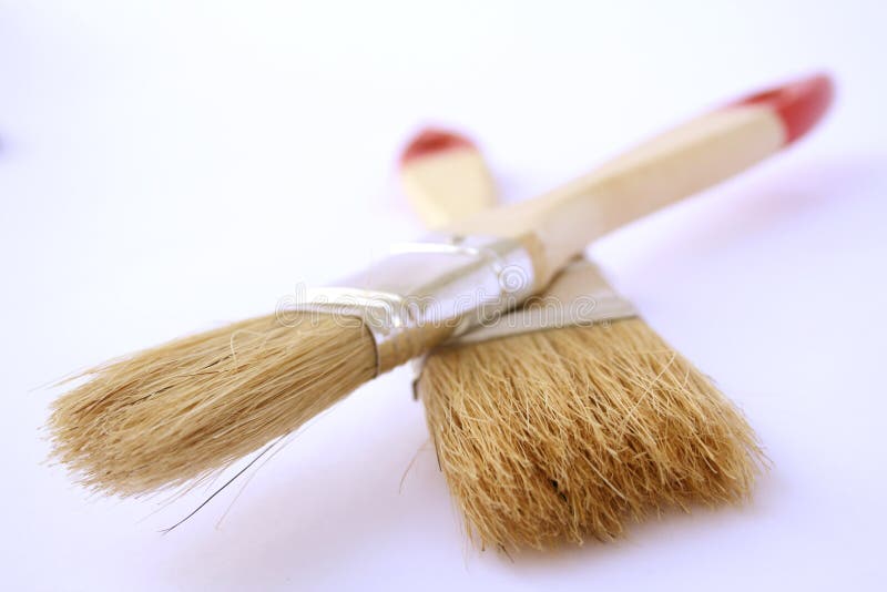 Two painting brushes with red handles on a paper on a diagonal royalty free stock photo