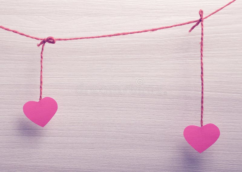 Two paper hearts hanging on a rope. Valentines day theme.