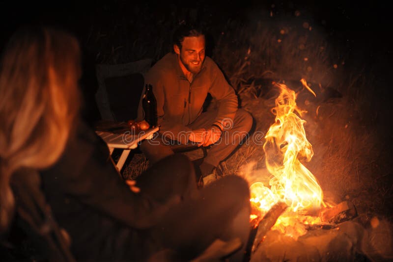 Man Sitting Next To a Bonfire in the Dark Stock Image Image of