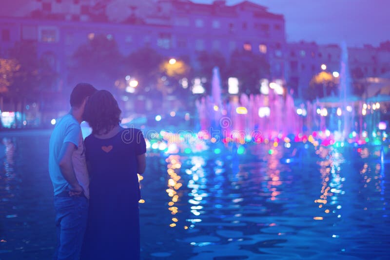 Two people enjoying evening city lights in Tirana