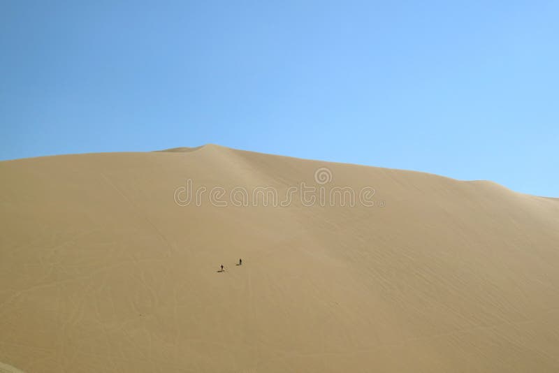 Two people having fun on the vast sand dune of Huacachina desert, Ica region, Peru, South America. Beauty in nature, adventure, arabian, attraction, beautiful stock photo Two people having fun on the vast sand dune of Huacachina desert, Ica region, Peru, South America. Beauty in nature, adventure, arabian, attraction, beautiful stock photo