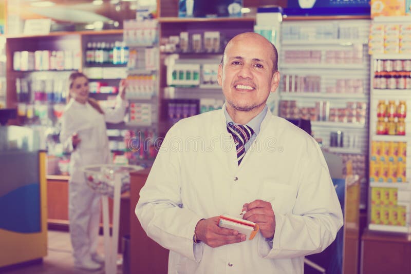 Friendly team of pharmaceutist and assistant working in chemist shop and smiling. Friendly team of pharmaceutist and assistant working in chemist shop and smiling