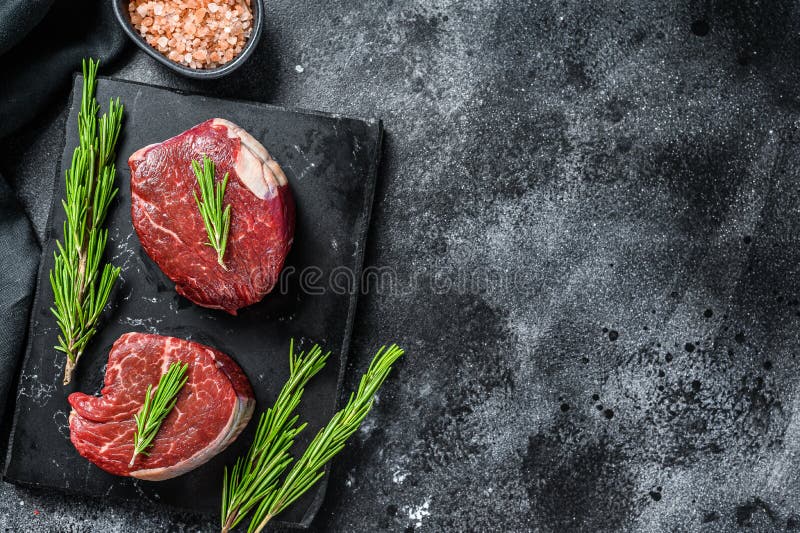 Two Pieces of Thin Steak Cut from the Tenderloin. Black Background. Top