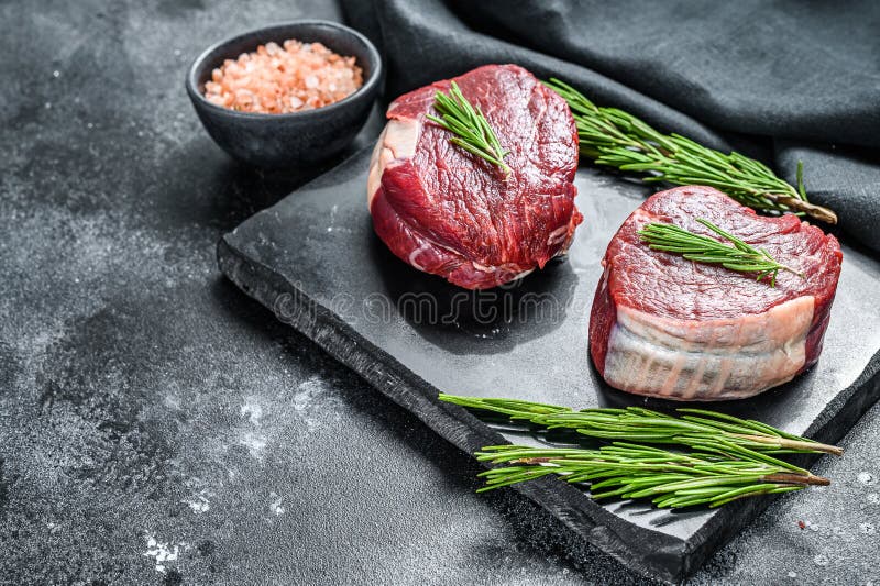 Two Pieces of Thin Steak Cut from the Tenderloin. Black Background. Top