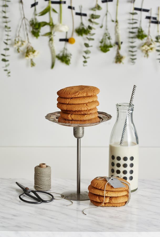 Two Piles of Cookies, a Glass Bottle of Milk, Scissors and a Spool
