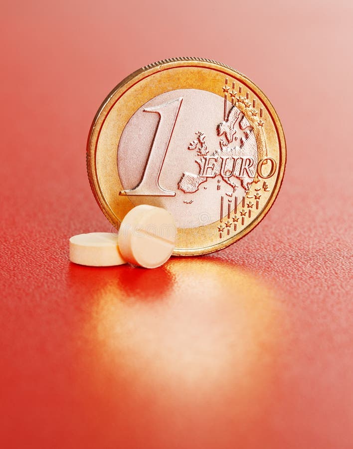 Two pills in front of one euro coin