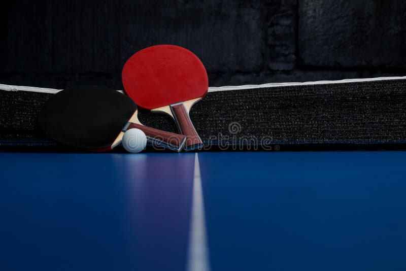 Two Ping Pong Rackets. Table Tennis Rackets and a Ball on a Blue Tennis