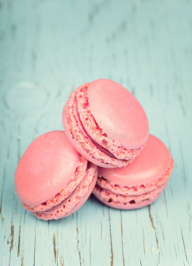 Two pink macaroons on wooden blue background royalty free stock image