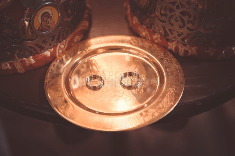 Two plain golden wedding rings on copper salver