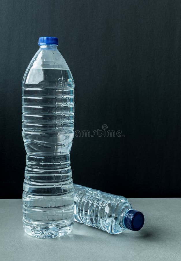 https://thumbs.dreamstime.com/b/two-plastic-bottles-filled-mineral-water-one-large-standing-small-lying-blue-caps-black-background-180979794.jpg