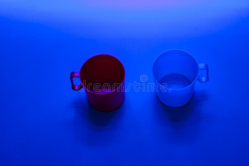 Two Plastic Cups on Blue Background. Conceptual Image with Copy Space