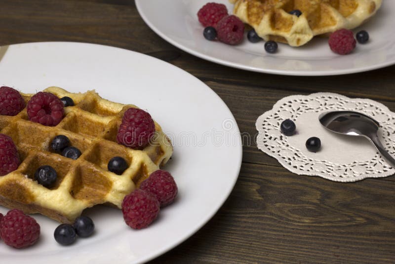 Two plates of waffles with berries stock photos