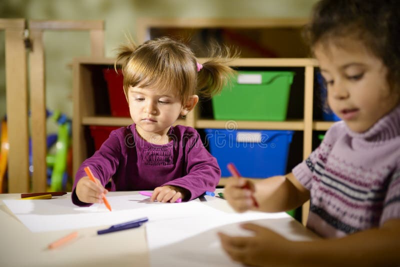 Two preschoolers drawing in kindergarten stock photography Two preschoolers drawing in kindergarten stock photography