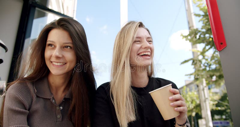 Two Pretty Girls Relaxing And Have Conversation And Drink Coffee In Street Stock Footage Video