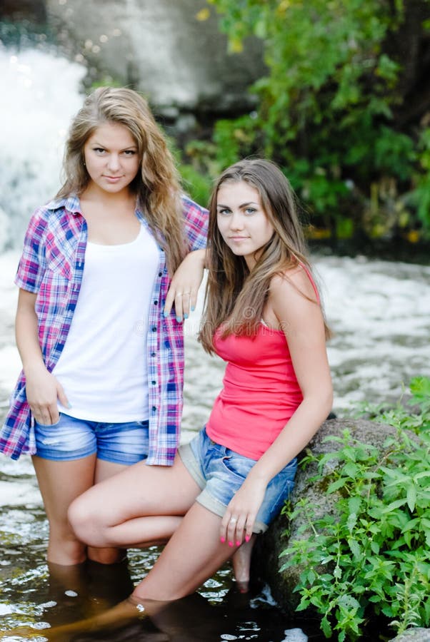 Two Teen Girls And Summer Outdoors Near Waterfall Stock