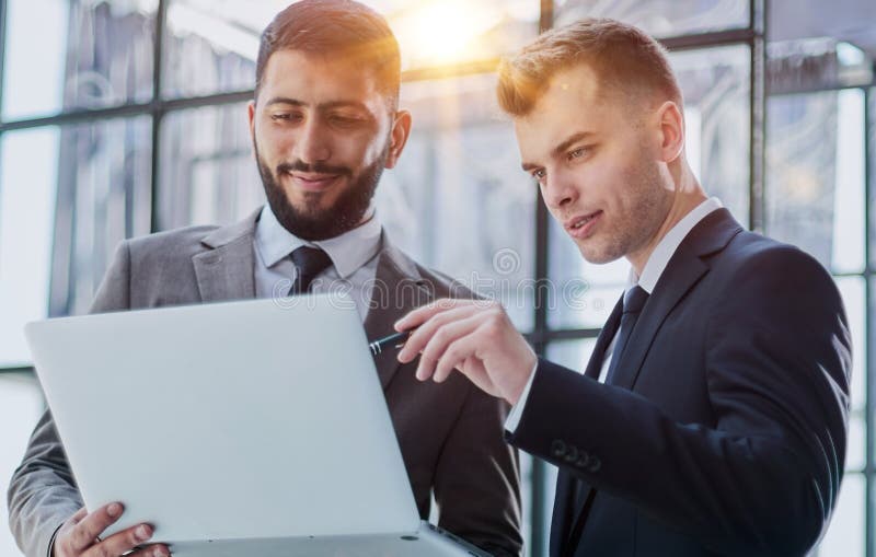 Two professional businessmen discussing and using desktop computer in office stock photos