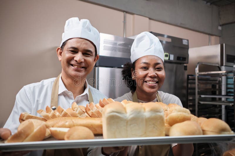Two Professional Chefs with Baking Bread, Smile and are Cheerful in the