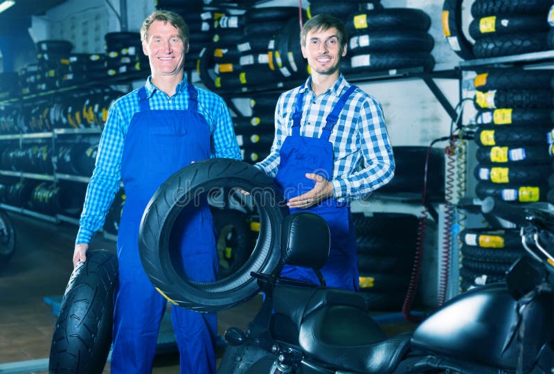 Two Professional Males Colleagues Working with Motorcycle Tires Stock