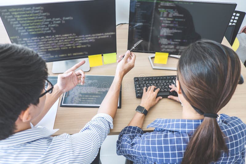 Two professional programmers cooperating at Developing programming and website working in a software develop company office, writing codes and typing data code. Developing programmer stock images, royalty-free photos and pictures