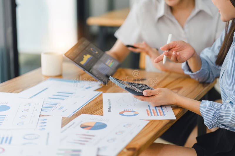 Two professionals analyzing business data on dashboard screen and discussing financial graphs and charts in a modern royalty free stock image