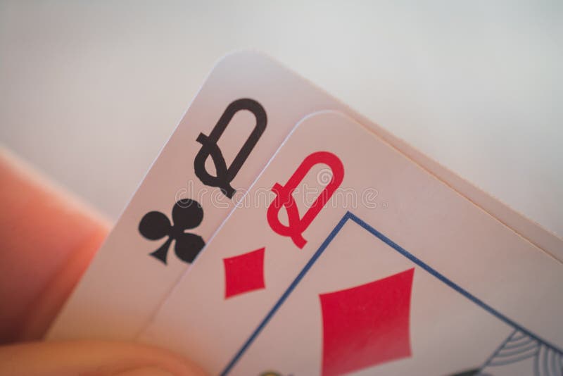 Two Queens, Playing Cards in Hand on the Table, Poker Nands Stock Photo