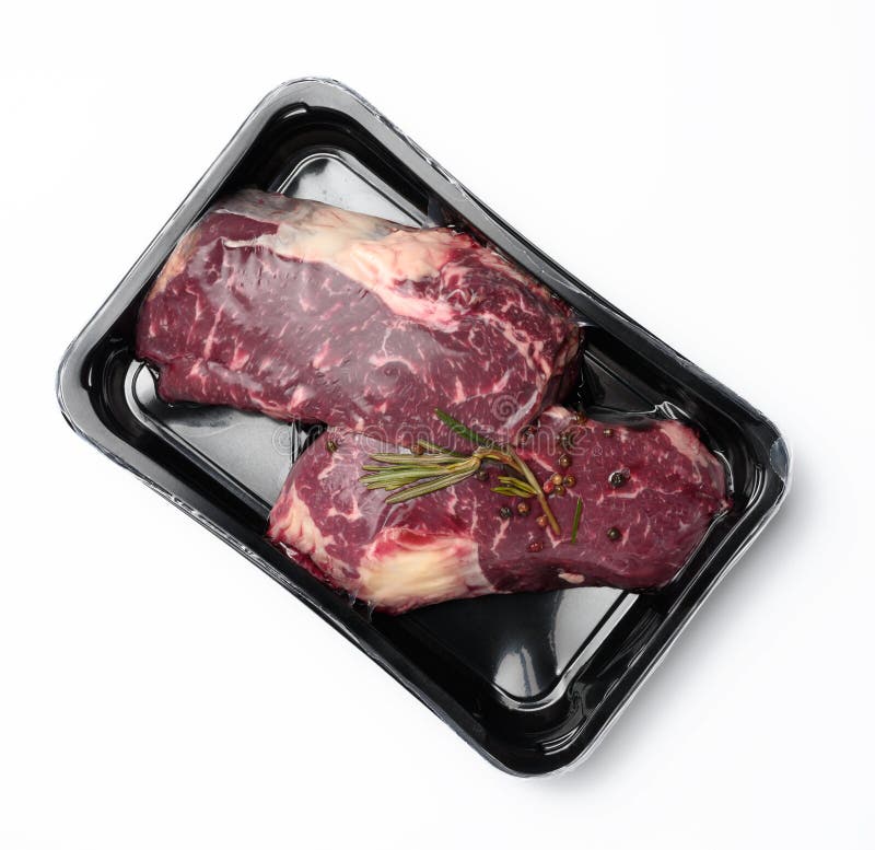 Two Raw Beef Steaks in a Plastic Container with Spices and Vacuumized