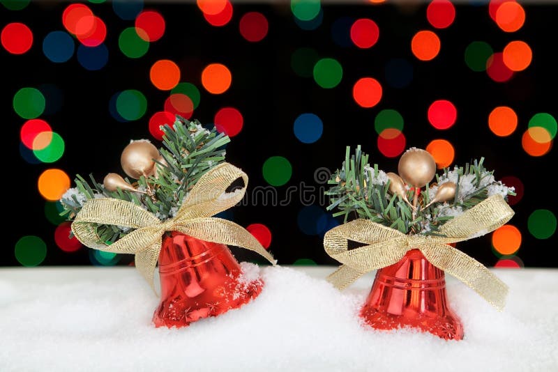 Two red Christmas bells in the snow.