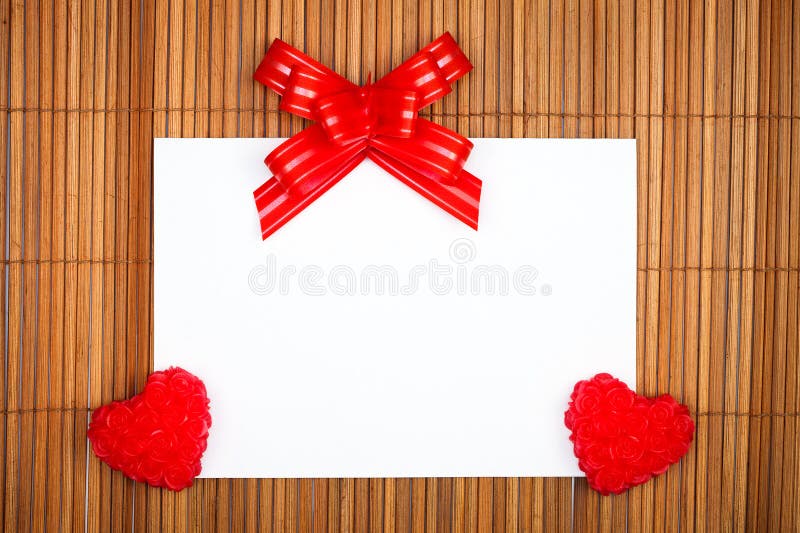 Two red hearts and bow with paper card