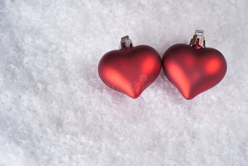 Two red hearts on snow