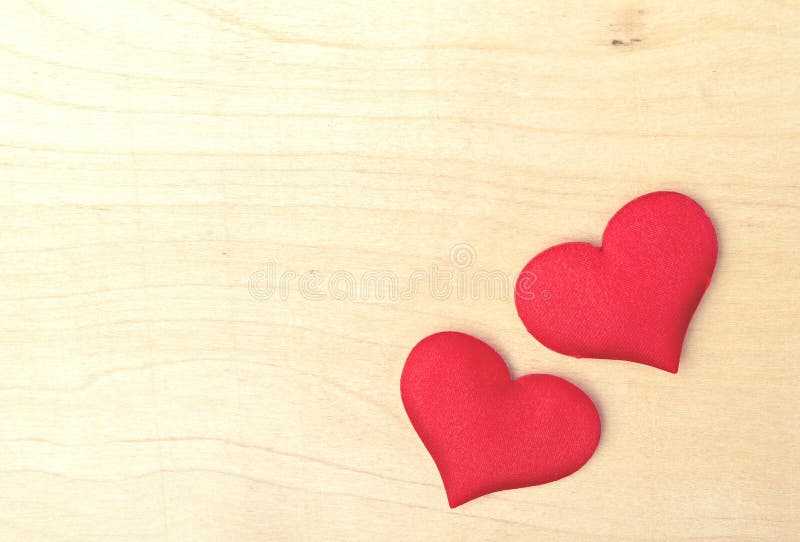 Two red hearts on a wooden board