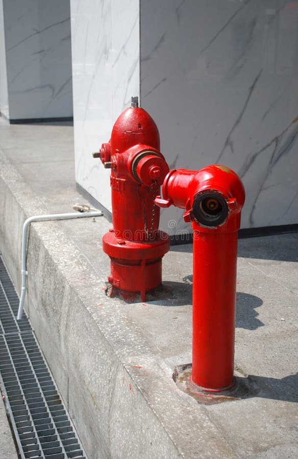 Two red hydrant on the sidewalk