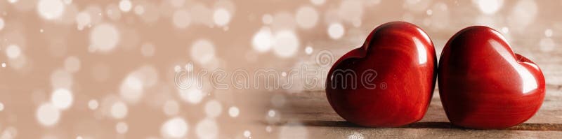 Two red wooden hearts symbol of love on wooden background and bokeh lights, Saint Valentine Day celebration, copy space for text. Two red wooden hearts symbol of love on wooden background and bokeh lights, Saint Valentine Day celebration, copy space for text