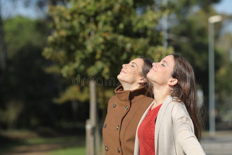 Two relaxed women breathing fresh air in winter in a park royalty free stock images Two relaxed women breathing fresh air in winter in a park royalty free stock images