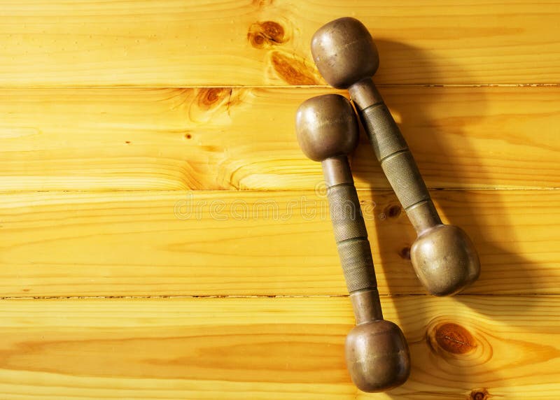 Two retro dumbbells on the wooden background stock image Two retro dumbbells on the wooden background stock image