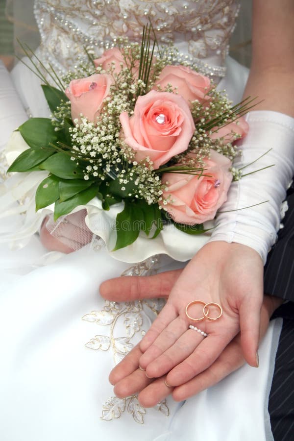 Dos anillos sobre el palmeras de, de rosas en mano.