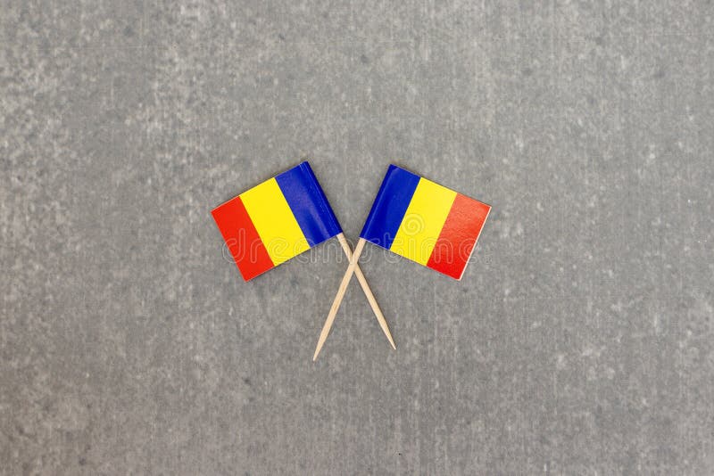 Two Romania Mini Flags on Toothpicks Over Grey Surface stock image