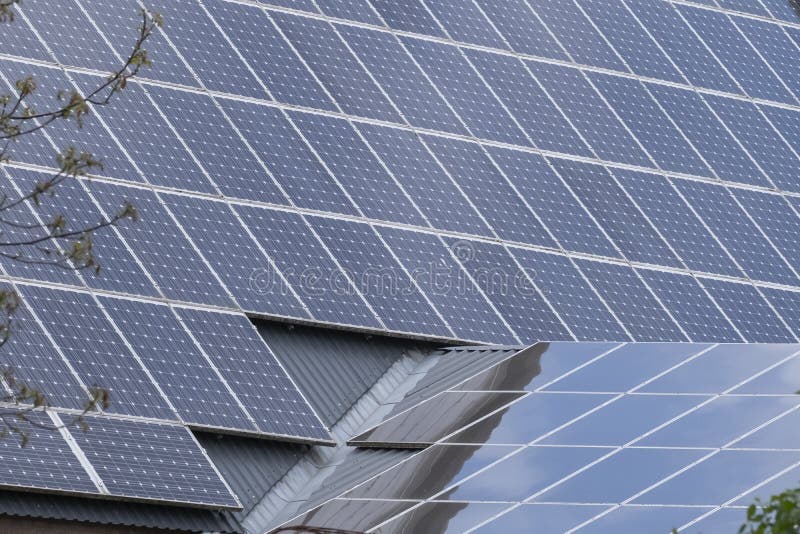 Two Roofs with Solar Panel Reflecting the Clouds En Trees. in the